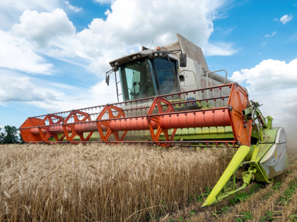 Farmers harvest a wheat field in the Ukrainian Kharkiv region on July 19, 2022, amid Russi