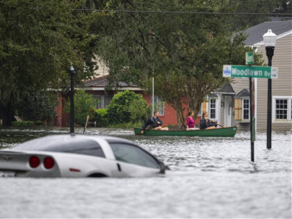 People paddle by in a canoe next to a submerged Chevy Corvette in the aftermath of Hurricane Ian in Orlando, Florida on September 29, 2022. - Hurricane Ian left much of coastal southwest Florida in darkness early on Thursday, bringing "catastrophic" flooding that left officials readying a huge emergency response …