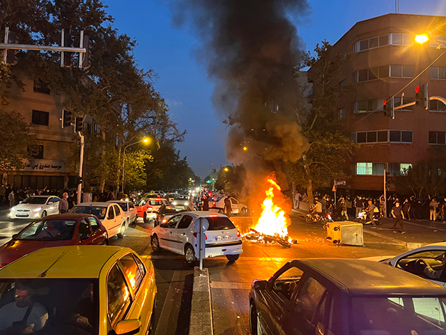 In this Sept. 19, 2022, photo taken by an individual not employed by the Associated Press and obtained by the AP outside Iran, a police motorcycle burns during a protest over the death of a young woman who had been detained for violating the country's conservative dress code, in downtown …