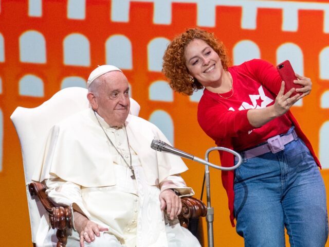 A believer, takes the stage for a selfie with Pope Francis (Jorge Mario Bergolgio) at the