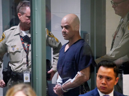 FILE - Clark County Public Administrator Robert "Rob" Telles is escorted into court on Sept. 8, 2022, in Las Vegas. Telles is due to be formally charged Tuesday, Sept. 13, 2022, with “premeditated” murder in the stabbing death of a Las Vegas investigative reporter who authorities said clawed and fought …