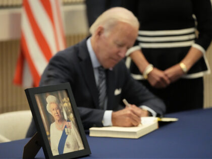 US President Joe Biden signs a condolences book with First Lady Jill Biden while paying re