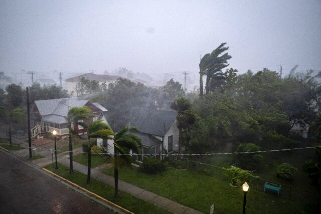 Gusts from Hurricane Ian whip palm treets in Punta Gorda, Florida