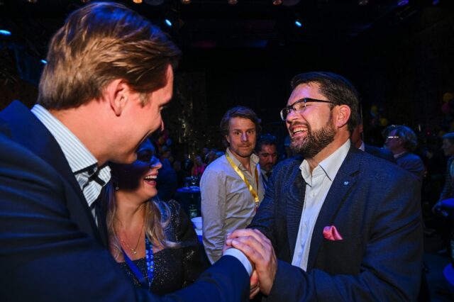 The leader of the Sweden Democrats, Jimmie Akesson (R), celebrates at the party's election