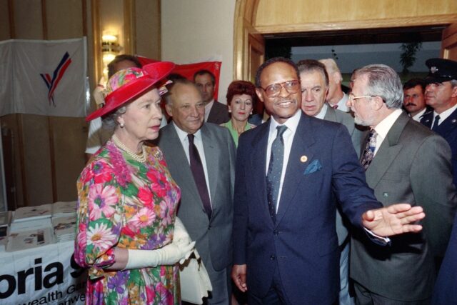 Queen Elizabeth II listens to Commonwealth chief Emeka Anyaoku of Nigeria (R) as Cypriot P