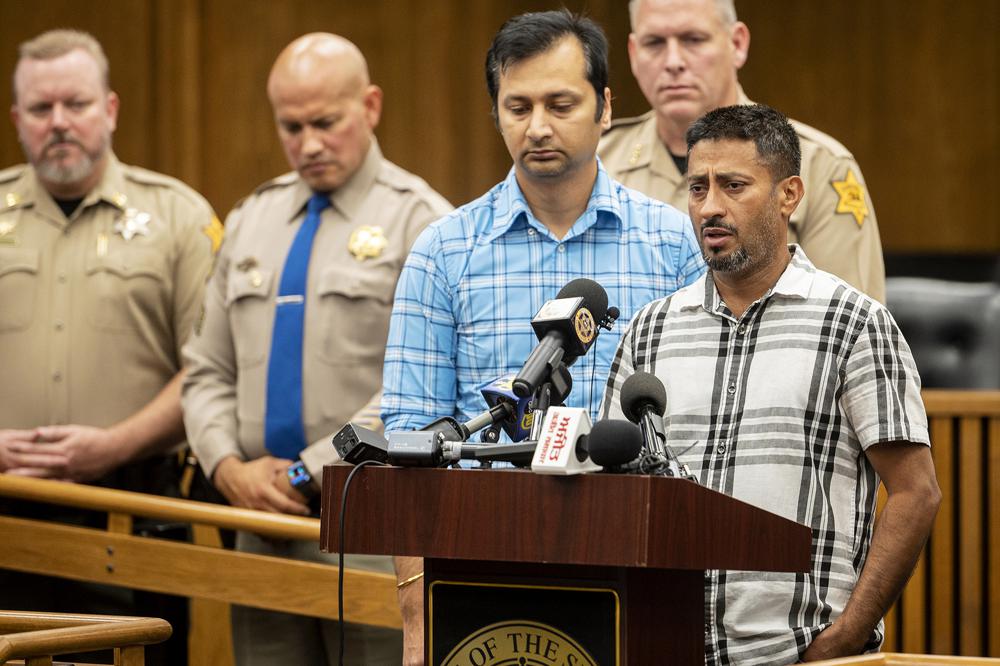Sukhdeep Singh, right, and Balwinder Saini, middle, speak about the kidnapping of their family members, 8-month-old Aroohi Dheri, her mother Jasleen Kaur, her father Jasdeep Singh, and her uncle Amandeep Singh at a news conference in Merced, Calif., on Wednesday, Oct. 5, 2022. Relatives of the family kidnapped at gunpoint from their trucking business in central California pleaded for help Wednesday in the search for them. Authorities say were taken by a convicted robber who tried to kill himself a day after the kidnappings. (Andrew Kuhn/The Merced Sun-Star via AP)