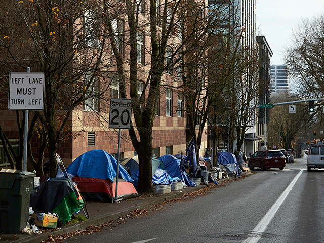 Tents line the sidewalk on SW Clay St in Portland, Ore., on Dec. 9, 2020. People with disabilities in Portland have filed a class action lawsuit in federal court, Thursday, Sept. 8, 2022, claiming the city has failed to keep sidewalks accessible by allowing homeless tents and encampments to block sidewalks. (AP Photo/Craig Mitchelldyer, File)