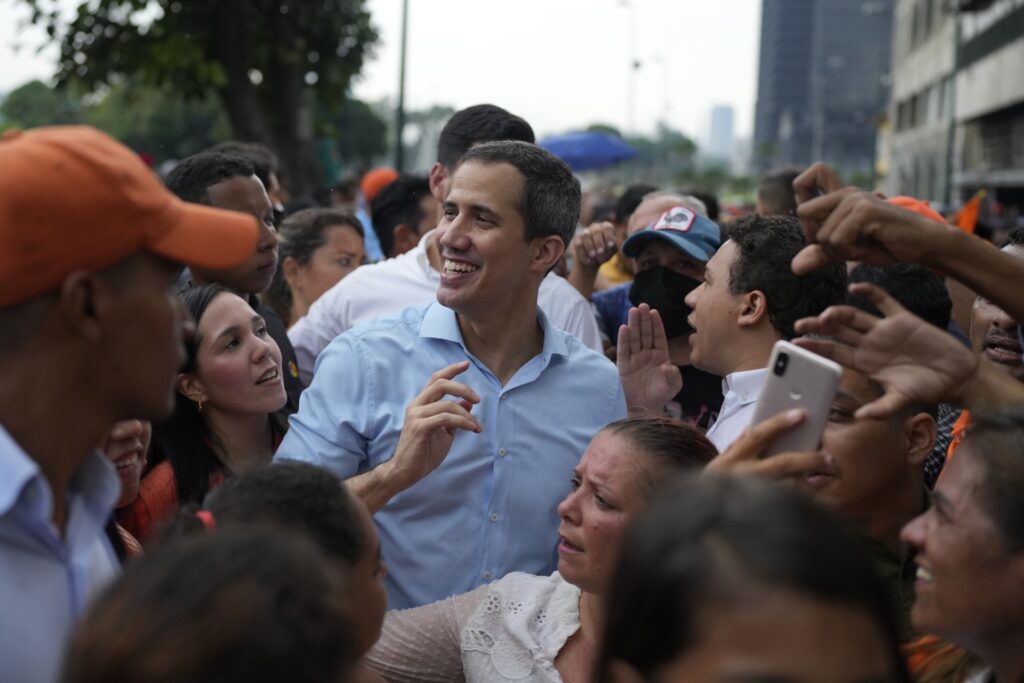 Surrounded by supporters, Venezuelan opposition leader Juan Guaido smiles during a rally in Caracas, Venezuela, Thursday, Oct. 27, 2022. (AP Photo/Ariana Cubillos)