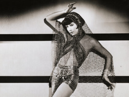Chinese-American actress Anna May Wong strikes a dancer's pose in a costume of veils.