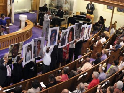 In this photo taken June 19, 2015, photos of the victims of the shooting at Emanuel AME Church in Charleston, S.C., are held during a vigil at the Metropolitan African Methodist Episcopal Church in Washington. The black church has long been the cornerstone and sanctuary for African American life. It …