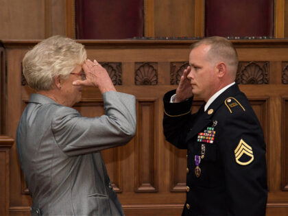 Staff Sgt. Donald McCook of the ALNG's 214th Military Police Company salutes Alabama governor Kay Ivey after being awarded his Purple Heart for actions and sacrifice on tour in Iraq. (Photo by Army Staff Sgt. William Frye.)