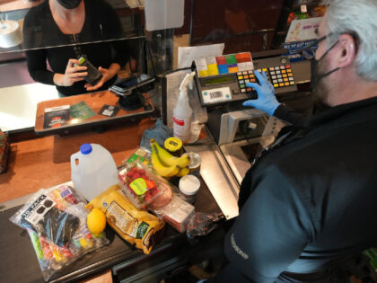 A cashier assists a customer at a checkout counter at Harmons Grocery store in Salt Lake C