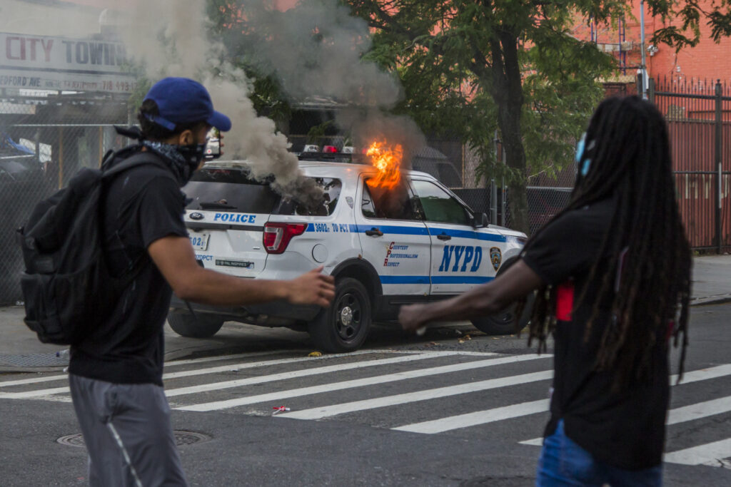 NEW YORK, NEW YORK - MAY 30: A police car is fired with fire during the protest in response to the death of African American George Floyd at the hands of Minneapolis, Minnesota police, on May 30, 2020 in the Brooklyn borough of New York City. The protests spread across cities in the U.S., and in other parts of the world. (Photo by Pablo Monsalve / VIEWpress via Getty Images)