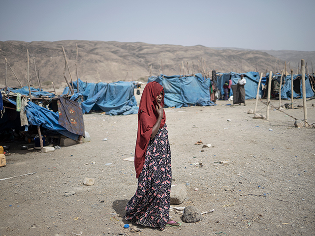 A woman walks past a tent at the internally displaced persons (IDP) camp of Guyah, 100 kms of Semera, Afar region, Ethiopia on May 17, 2022. - Conflict erupted in Ethiopia late 2020 when the government sent troops in to topple Tigray's ruling TPLF party, saying it was in response …
