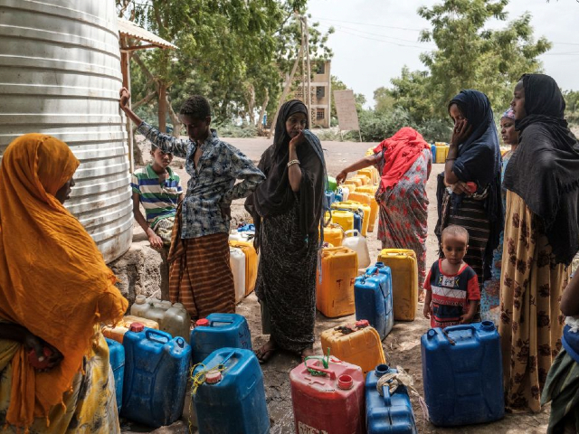 People collect water from a tank in a compound of abandoned buildings, where internally displaced people are sheltered, near the town of Dubti, 10 kilometers from Semera, Ethiopia, on June 7, 2022. - The Afar region, the only passageway for humanitarian convoys bound for Tigray, is itself facing a serious food crisis, due to the combined effects of the conflict in northern Ethiopia and the drought in the Horn of Africa which have notably caused numerous population displacements. More than a million people need food aid in the region according to the World Food Programme. (Photo by EDUARDO SOTERAS / AFP) (Photo by EDUARDO SOTERAS/AFP via Getty Images)