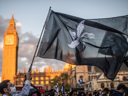 LONDON, UNITED KINGDOM - 2022/08/31: Protesters wave banners that say "Liberate Hong Kong, Revolution of our Times" in front of the Palace of Westminster during the demonstration. Protesters gathered in London on the third anniversary of the Prince Edward station incident in Hong Kong. This incident is about Hong Kong …