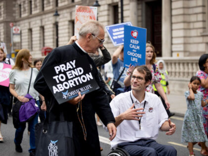 LONDON, UNITED KINGDOM - 2022/09/03: A priest is seen holding a placard while chatting with a pro-life advocate during the March for Life in central London. Religious Christians and pro-life advocates march in central London and demand the UK government to end abortion. They believe in life of conception and …