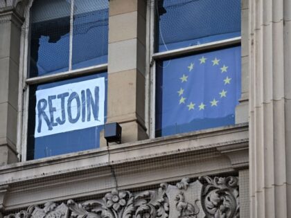 A rejoin the EU sign is seen in a window as anti-government protests take place on the opening day of the annual Conservative Party Conference in Birmingham, central England, on October 2, 2022. - New UK Prime Minister Liz Truss will have plenty of critics lying in wait at what …