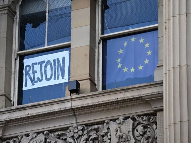 A rejoin the EU sign is seen in a window as anti-government protests take place on the ope