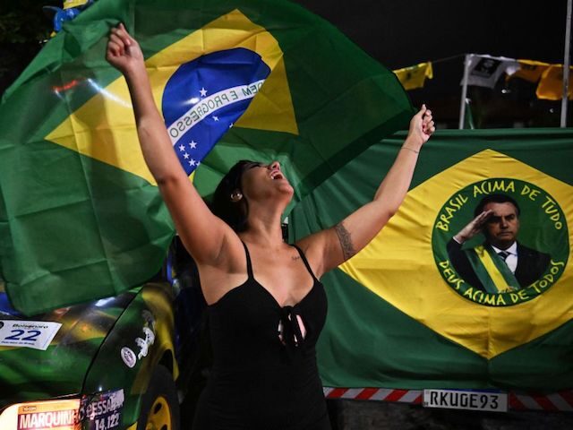 A supporter of Brazilian President and re-election candidate Jair Bolsonaro reacts as she watches the vote count of the legislative and presidential election, in Rio de Janeiro, Brazil, on October 2, 2022. - Brazilians voted Sunday in a polarizing presidential election which front-runner Luiz Inacio Lula da Silva hopes to …