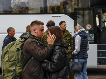 Russian recruits gather outside a military processing center as drafted men said goodbye t