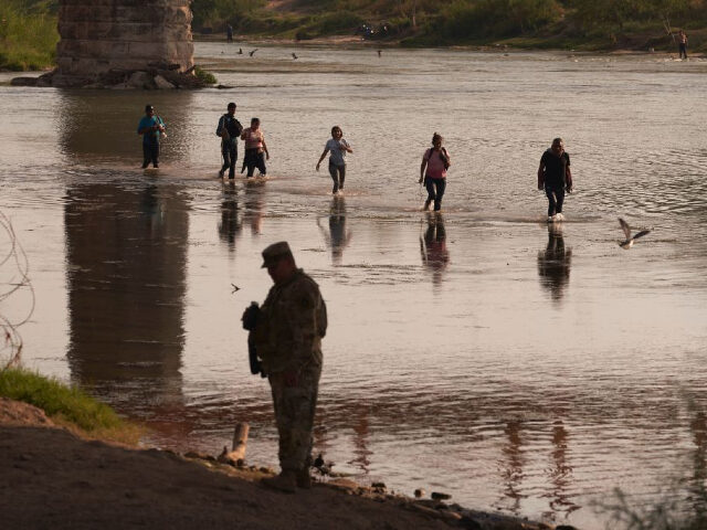 This picture taken on October 9, 2022 shows migrants illegally crossing the Rio Grande Riv