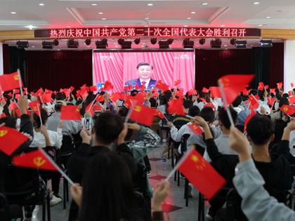 This photo taken on October 16, 2022 shows people waving national flags and Communist Party flags as they watch the opening session of the 20th Chinese Communist Party Congress in Huaibei, in Chinas eastern Anhui province. - President Xi Jinping hailed China's rise as a global power and demanded unity …