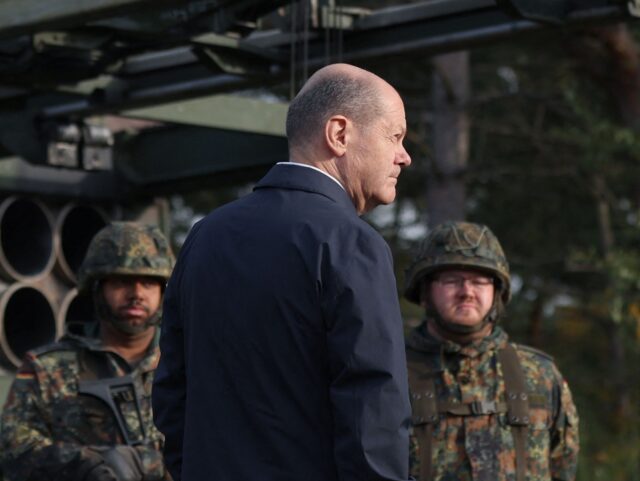 German Chancellor Olaf Scholz stands next to a Multiple Launch Rocket System (MLRS - MARS