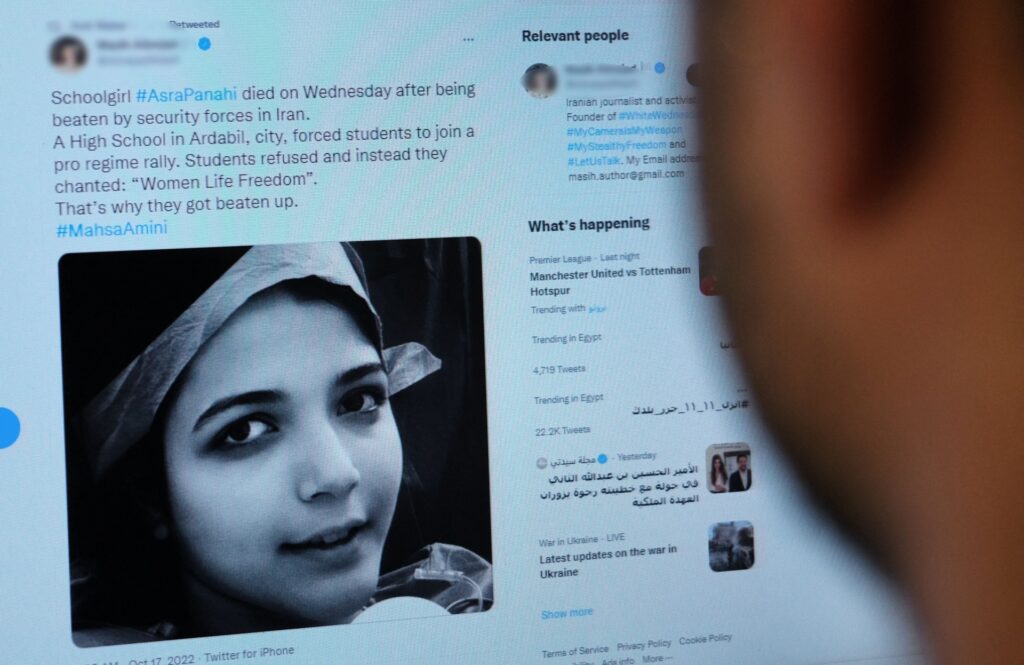 A person in Cairo looks on October 20, 2022 at a tweet about the reported death of 15-year-old Iranian girl Asra Panahi. - The 15-year-old Iranian girl died last week after being beaten during a raid by the security forces on her school, a teachers' union said, urging the authorities to stop killing "innocent" protesters. Asra Panahi died on October 13, after "plainclothes officers attacked" Shahed High School in the northwestern city of Ardabil, the Co-ordinating Council of Teachers Syndicates said. (Photo by AFP) (Photo by -/AFP via Getty Images)