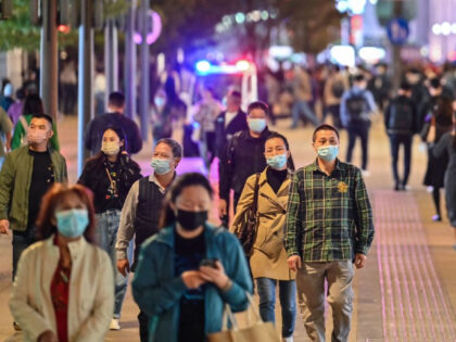 People walk along a pedestrian street surrounded by shops and shopping malls in Shanghai on October 24, 2022. (Photo by Hector RETAMAL / AFP) (Photo by HECTOR RETAMAL/AFP via Getty Images)