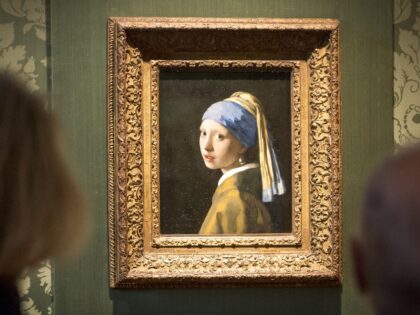 Visitors looks at the Johannes Vermeer's painting "Girl with a Pearl Earring" at the Mauritshuis museum in The Hague, 27 October 2022. - Dutch police arrested three people after climate activists targeted Johannes Vermeer's painting "Girl with a Pearl Earring". - Netherlands OUT (Photo by Lex van Lieshout / ANP …