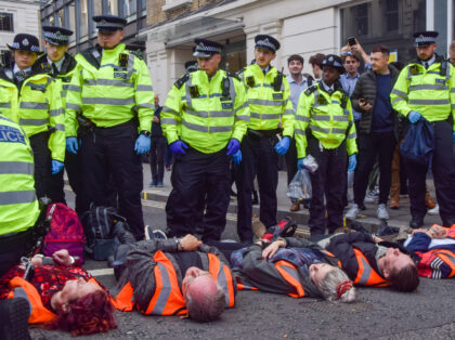 LONDON, UNITED KINGDOM - 2022/10/27: Police officers arrest protesters during the demonstration. Just Stop Oil activists glued their hands and locked themselves to metal pipes blocking the streets around Mansion House Station in the City of London, the capital's financial district, as they continue their protests demanding the government stops …