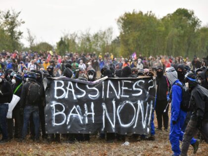 TOPSHOT - Activists hold a banner reading "Basins, well no" during a demonstration called by the collective "Bassines Non Merci" against the "basins" near the construction site of a new water reserve for agricultural irrigation, in Sainte-Soline, western France, on October 29, 2022. - The Sainte-Soline reserve is the second …