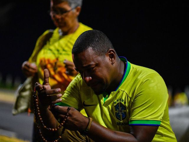 A supporter of Brazilian President and re-election candidate Jair Bolsonaro prays after his candidate lost the presidential runoff election in Rio de Janeiro, Brazil, on October 30, 2022. - Brazil's veteran leftist Luiz Inacio Lula da Silva was elected president Sunday by a hair's breadth, beating his far-right rival in a down-to-the-wire poll that split the country in two, election officials said. (Photo by ANDRE BORGES / AFP) (Photo by ANDRE BORGES/AFP via Getty Images)