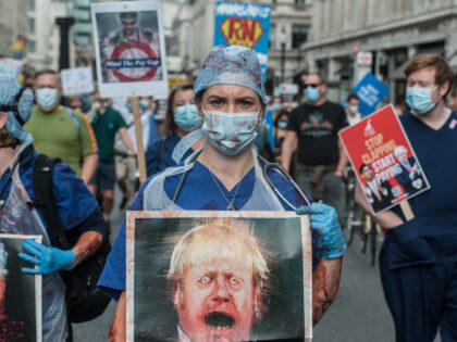 LONDON, ENGLAND - SEPTEMBER 12: An NHS worker covered in fake blood takes part in a march from the BBC headquarters to Trafalgar square to demand a pay rise from the government on September 12, 2020 in London, England. Nurses and NHS staff are protesting after being excluded from a …