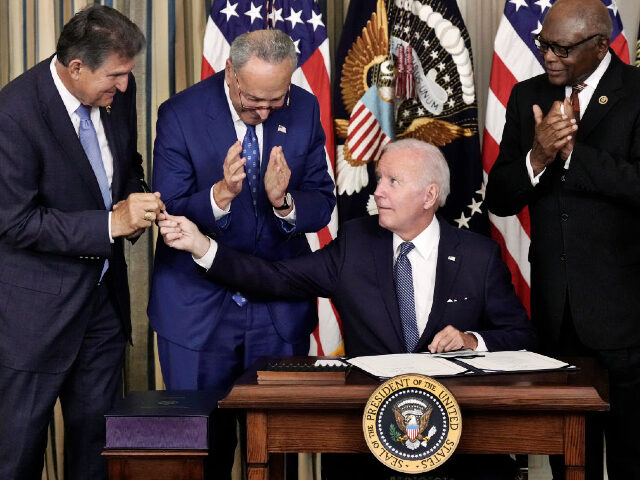 WASHINGTON, DC - AUGUST 16: U.S. President Joe Biden (C) gives Sen. Joe Manchin (D-WV) (L) the pen he used to sign The Inflation Reduction Act with Senate Majority Leader Charles Schumer (D-NY) and House Majority Whip James Clyburn (D-SC) in the State Dining Room of the White House August …