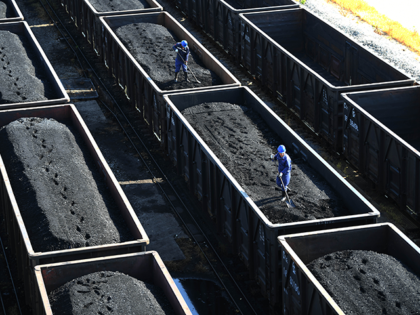 Employees work on a freight train loaded with coal at Jiangxi Coal Reserve Center on August 19, 2022 in Jiujiang, Jiangxi Province of China. (Photo by VCG/VCG via Getty Images)
