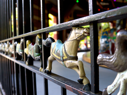 Metal horse carvings decorate the metal enclosure of the carousel at Central Park, Manhattan, New York