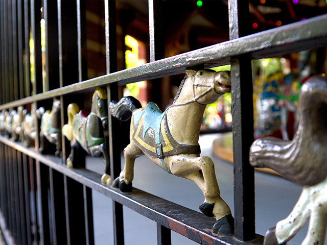 Metal horse carvings decorate the metal enclosure of the carousel at Central Park, Manhatt