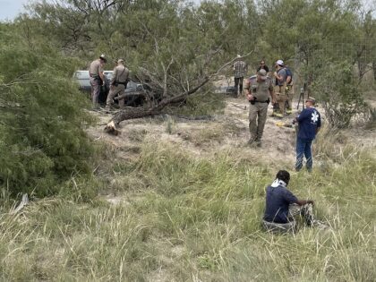 Texas DPS troopers and Kinney County Sheriff's Office deputies survey the wreckage of a hu