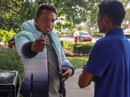 A recent Venezuelan migrant, left, who had been chosen by the recruiters as a sort of team captain of a work crew that helped with Hurricane Ian recovery, expresses anger toward Pedro Escalona, 24, for speaking to journalists on Oct. 10, 2022. (Carl Juste/Miami Herald/Tribune News Service via Getty Images)