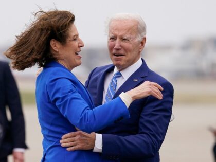 President Joe Biden greets Rep. Cindy Axne, D-Iowa, as he arrives on Air Force One at Des