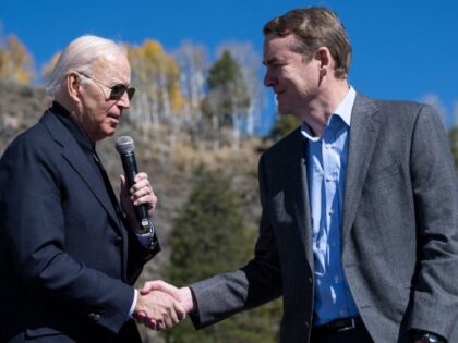 President Joe Biden shakes hands with Senator Michael Bennet (D-CO) while speaking about p