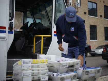 A worker loads mail into a delivery vehicle outside a United States Postal Service (USPS) distribution center in Chicago, Illinois, U.S., on Tuesday, Oct. 12, 2021. FedEx, UPS, Amazon.com and the U.S. Postal Service are busy hiring temporary and part-time workers ahead of the peak season, which will start to …