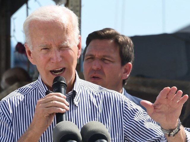 President Joe Biden speaks in a neighborhood impacted by Hurricane Ian at Fisherman’s Pass in Fort Myers, Florida, on October 5, 2022, as Florida Governor Ron DeSantis looks on. (OLIVIER DOULIERY/AFP via Getty Images)