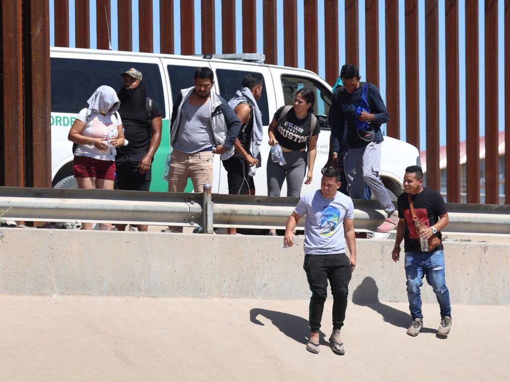 EL PASO, TEXAS - SEPTEMBER 21: Venezuelan migrants walk along the U.S. border fence to turn themselves in to the U.S. Border Patrol after crossing the Rio Grande from Mexico on September 21, 2022 in El Paso, Texas. In recent weeks, Venezuelans have arrived in increasing numbers in El Paso. The city has had to scramble to find housing and other aid for the migrants. (Photo by Joe Raedle/Getty Images)