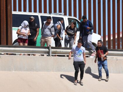 EL PASO, TEXAS - SEPTEMBER 21: Venezuelan migrants walk along the U.S. border fence to tur