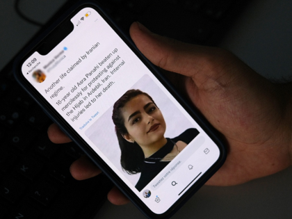 A person in Cairo looks on October 20, 2022 at a tweet about the reported death of 15-year-old Iranian girl Asra Panahi. - The 15-year-old Iranian girl died last week after being beaten during a raid by the security forces on her school, a teachers' union said, urging the authorities …