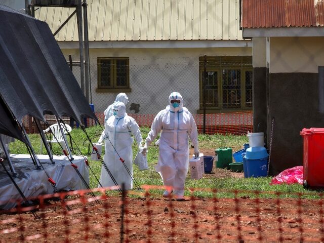 Doctors walk inside the Ebola isolation section of Mubende Regional Referral Hospital, in