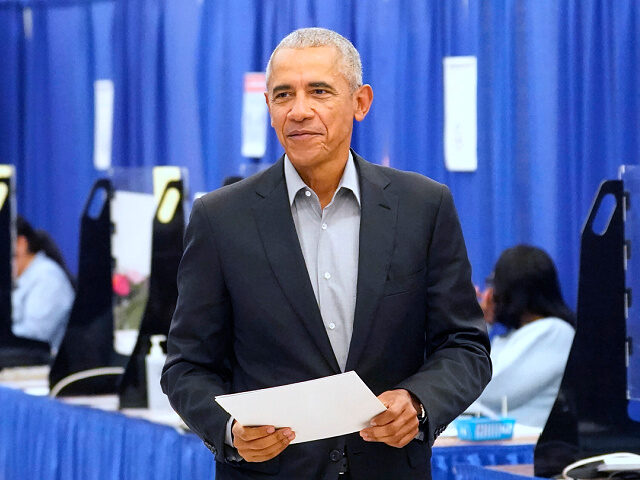 FILE - Former President Barack Obama heads to a voting machine to cast his ballot at an ea